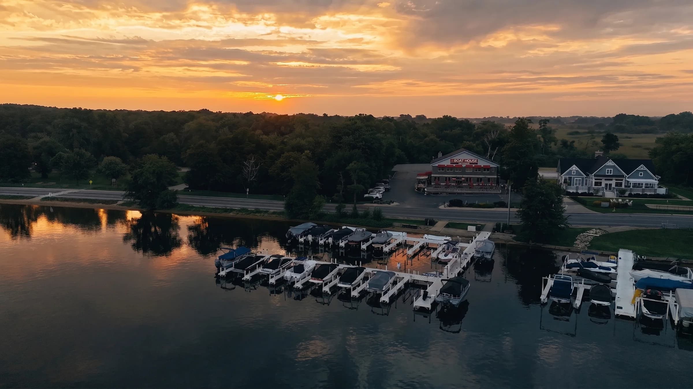 The Boat House and its marina from the air at sunset on Geneva Lake
